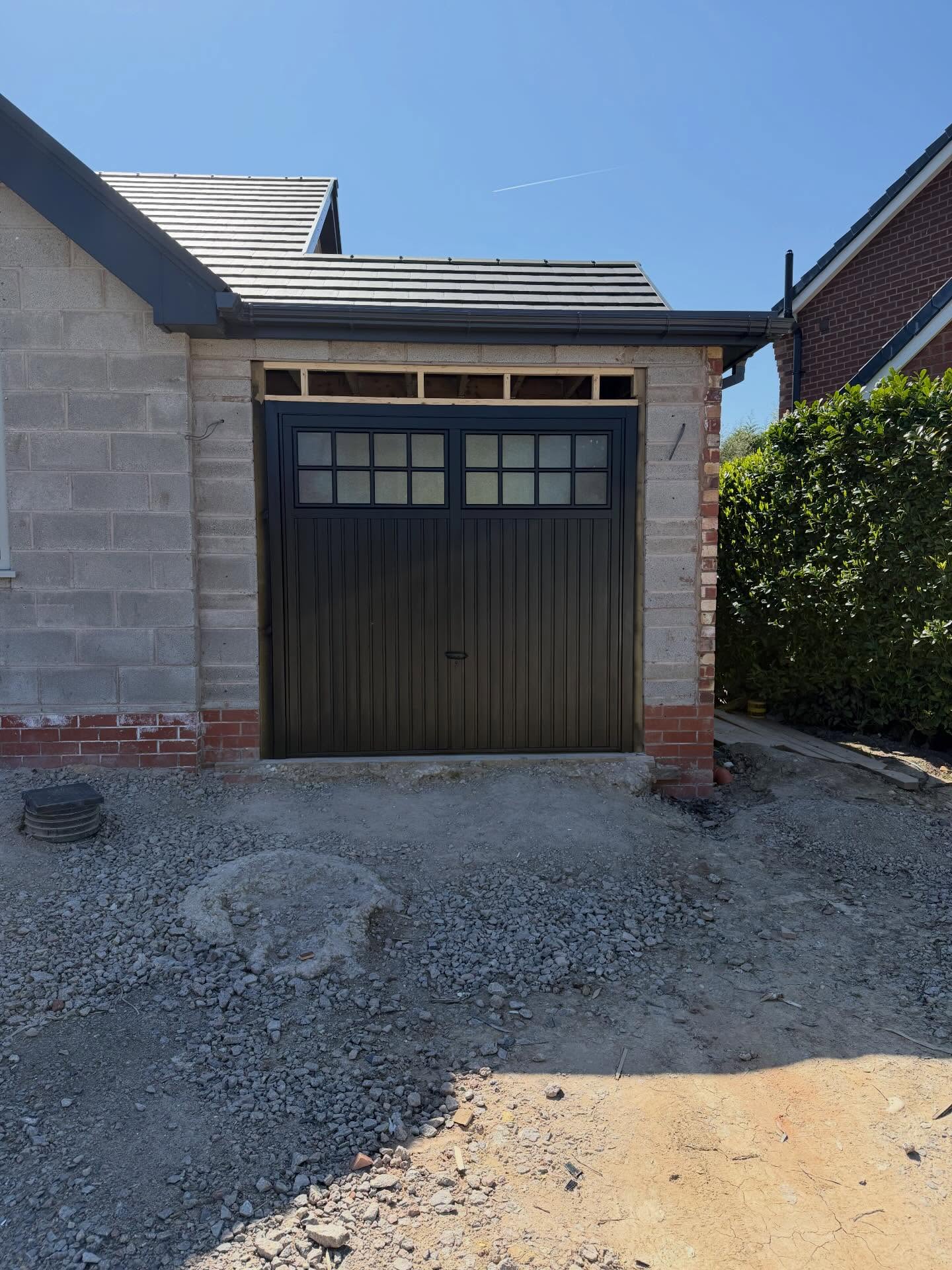 Garage door resprayed jet black with a smooth factory-quality finish.