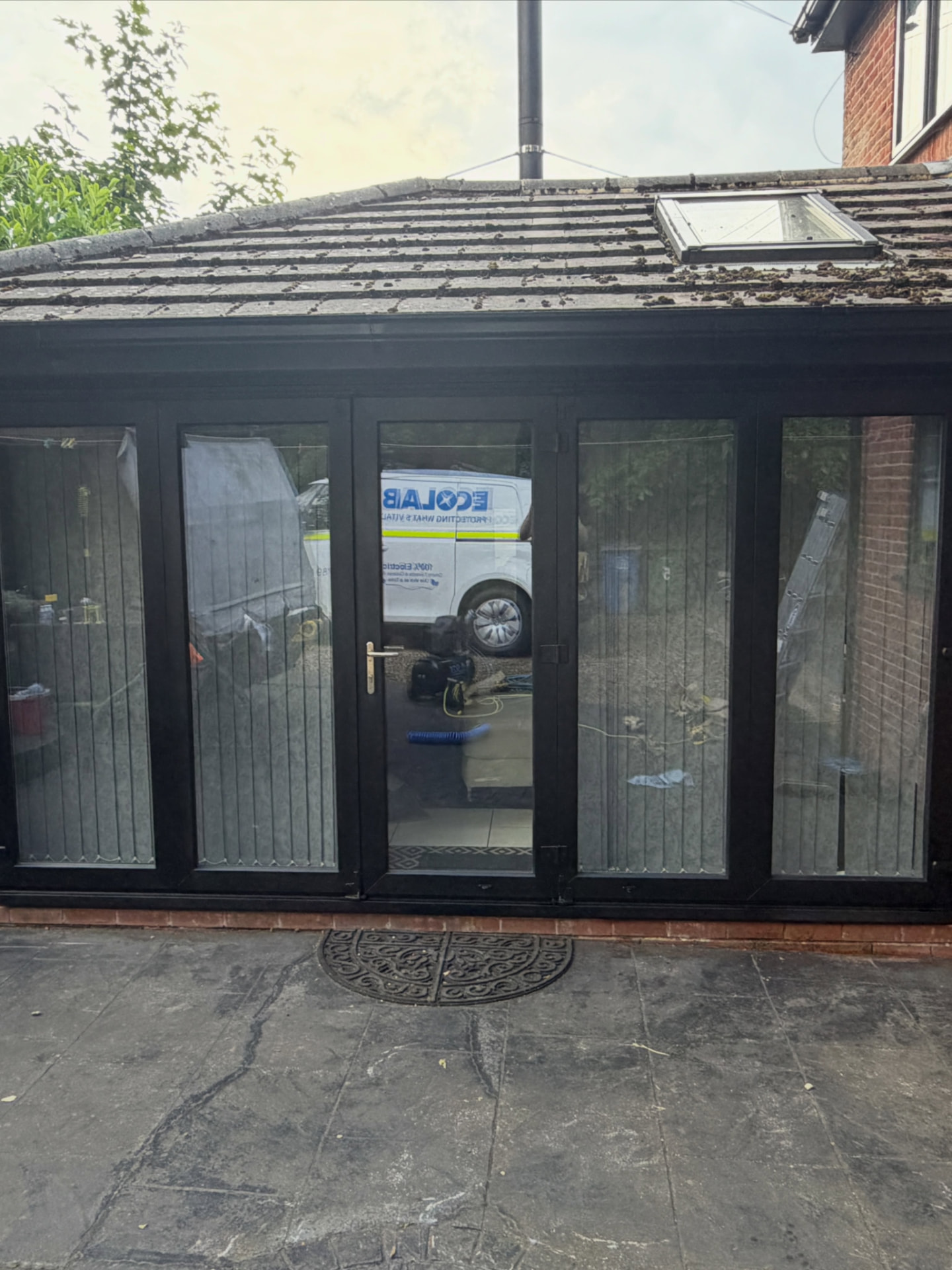 Exterior bifold doors and conservatory frame resprayed in a sleek black finish.