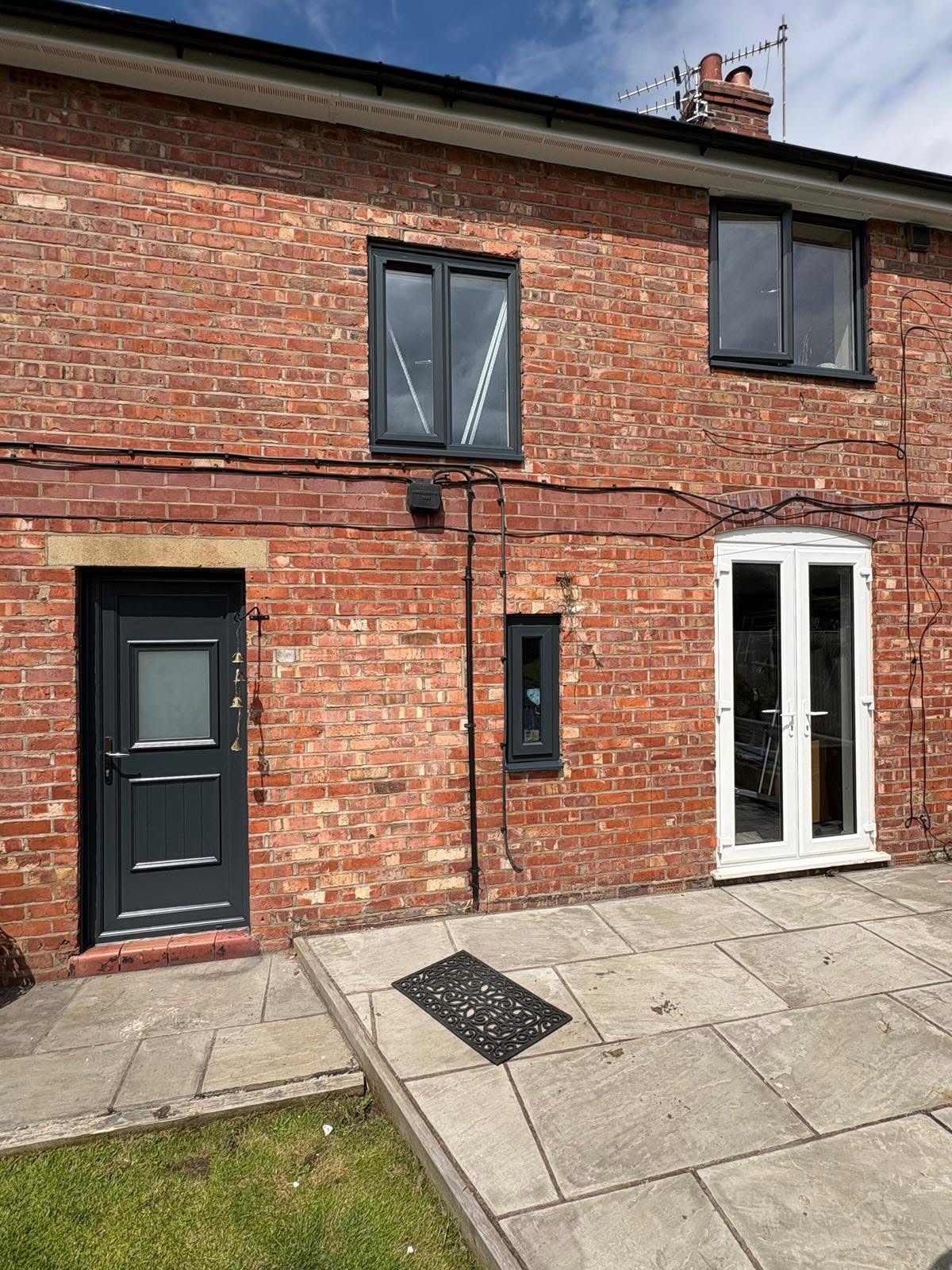 Rear elevation with windows, door and rainwater goods sprayed anthracite grey.