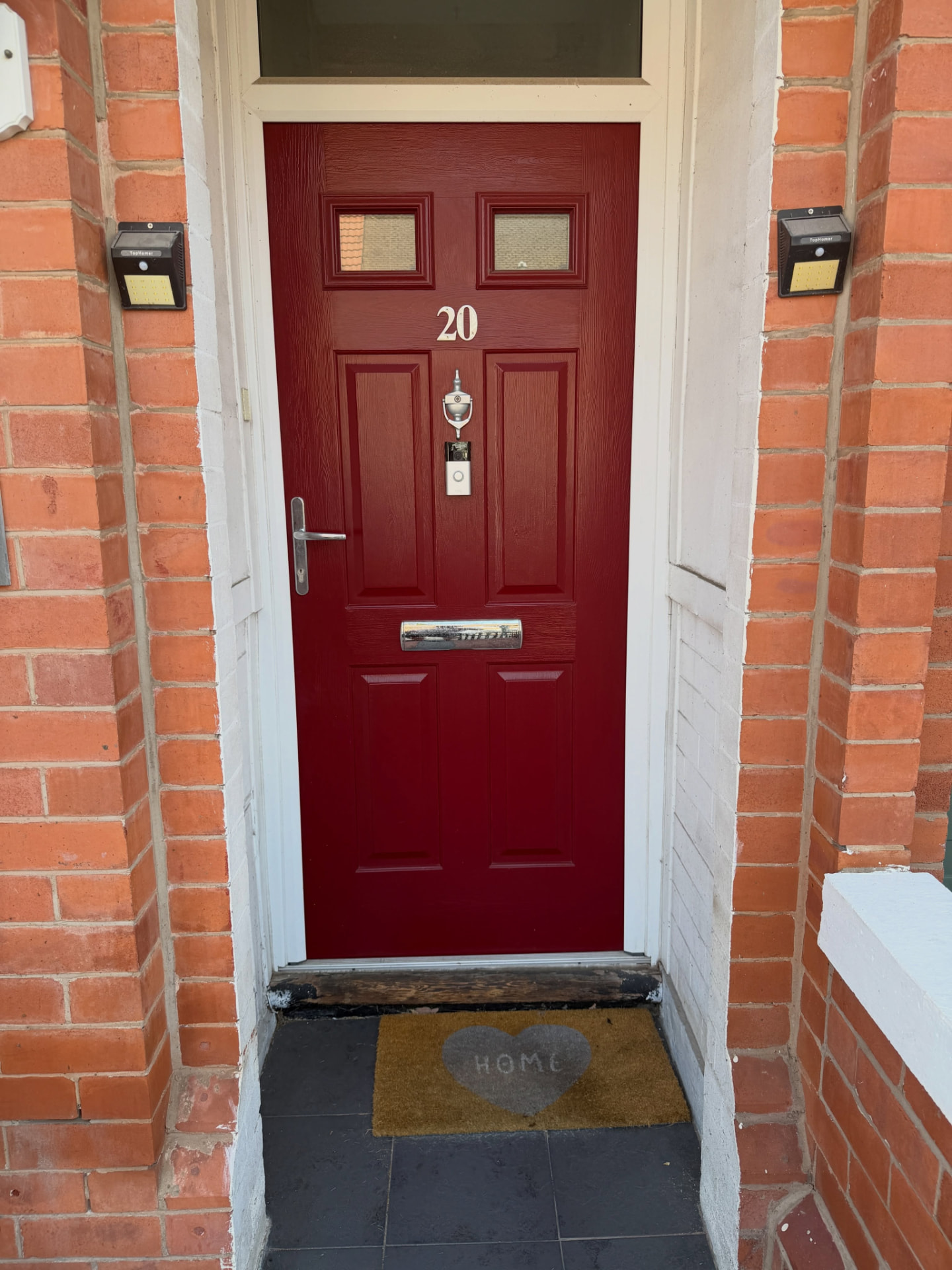 Composite front door resprayed in a deep red finish.